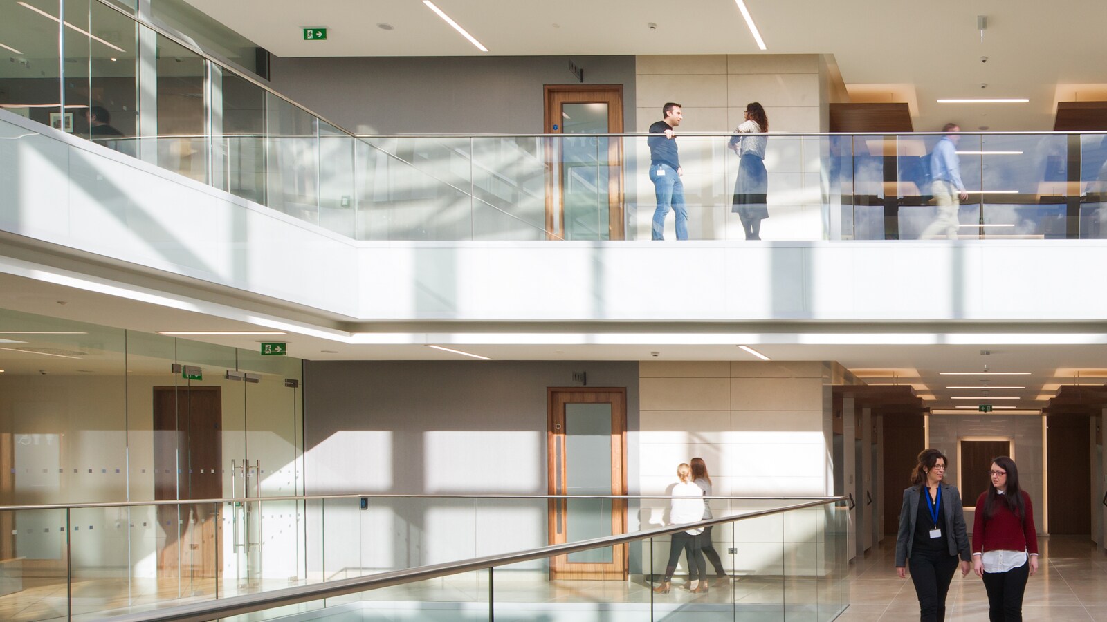 professionals standing on the glass rail balcony and talking