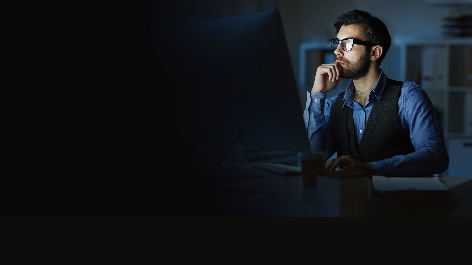 A man looking at a desktop screen.