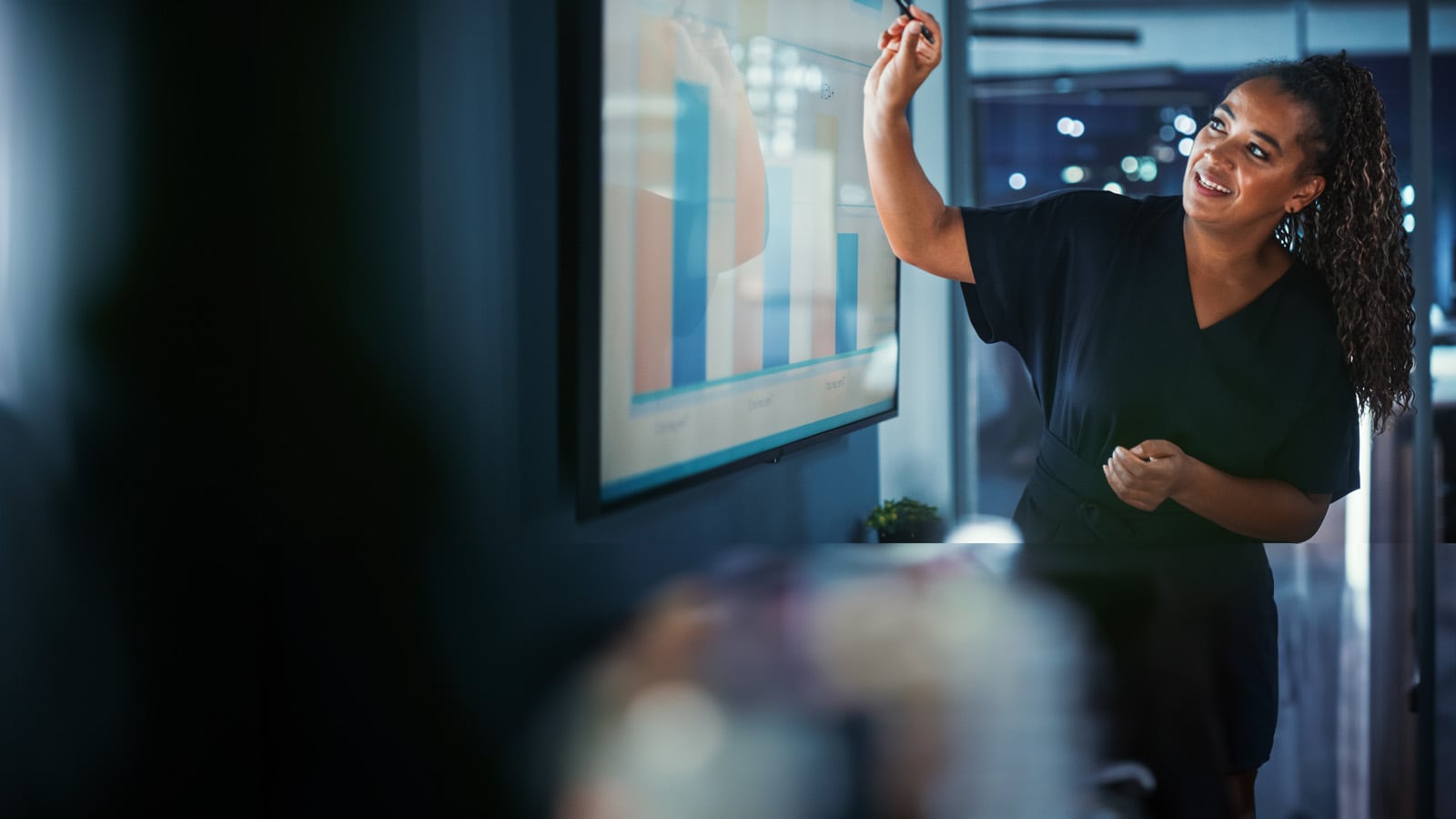 A Business professional presenting a data visualisation in a meeting.