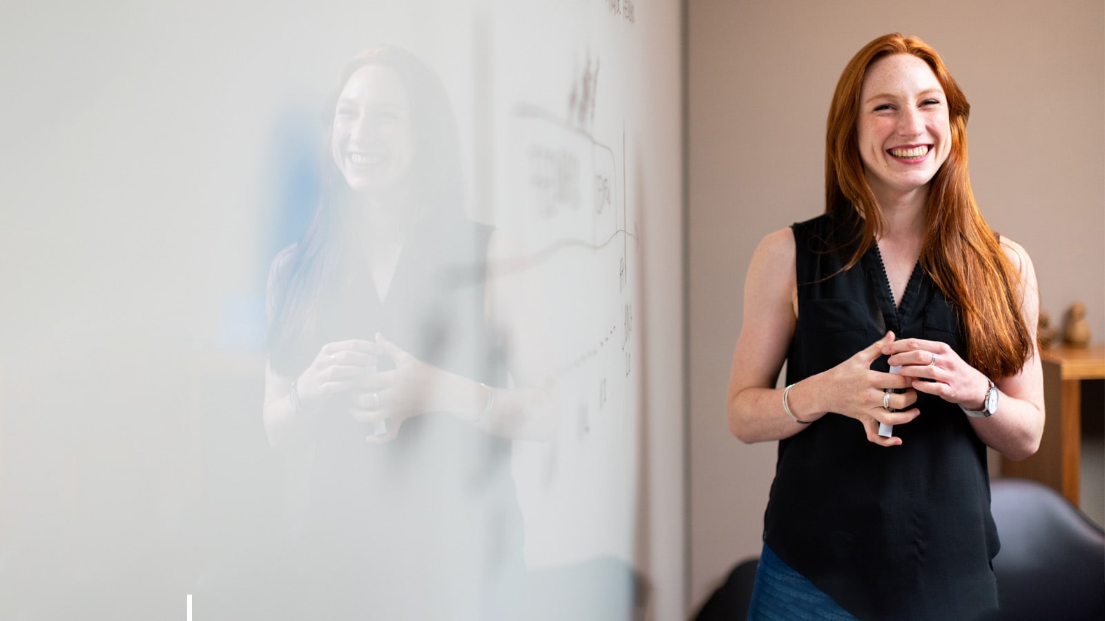 Person standing next to a whiteboard