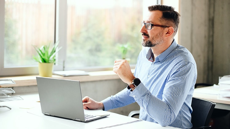 Man, sitting and using a laptop