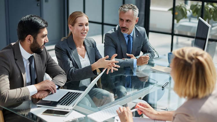 People talking in front of a laptop