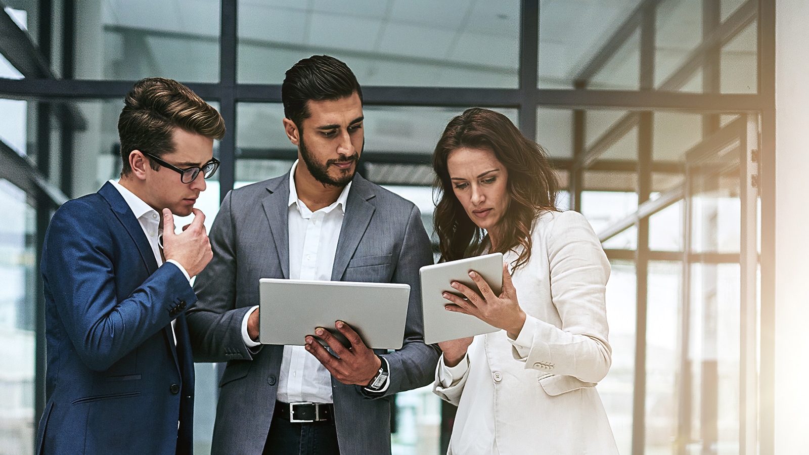 3 people looking at a tablet