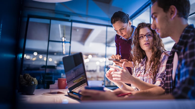 Workers looking at blueprints in a wind field