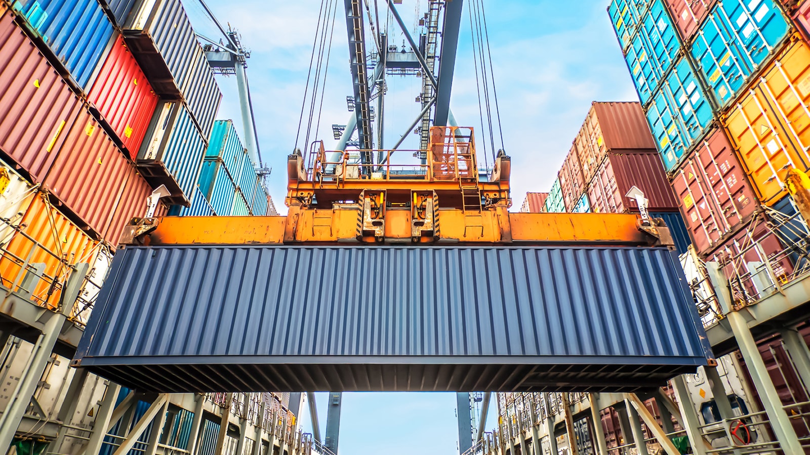 Shipping container being lifted at a busy port terminal