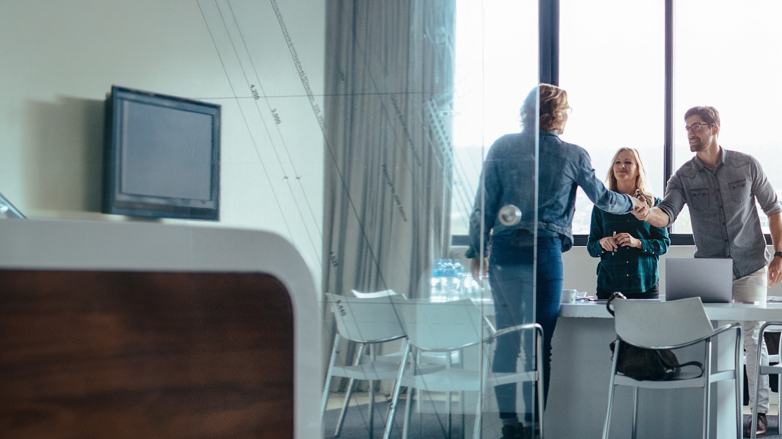 Three Business professionals having a discussion in a meeting room